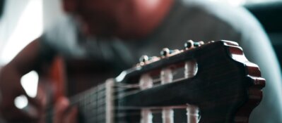 Porträt von H.E.P. mit Gitarre im Wohnzimmer